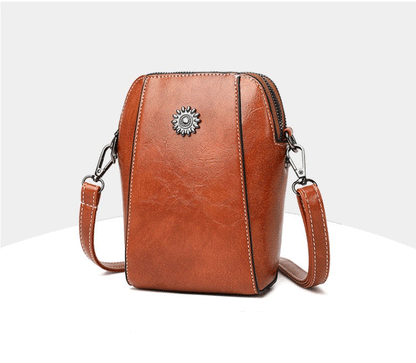 Brown mini crossbody handbag with zipper and sunburst emblem