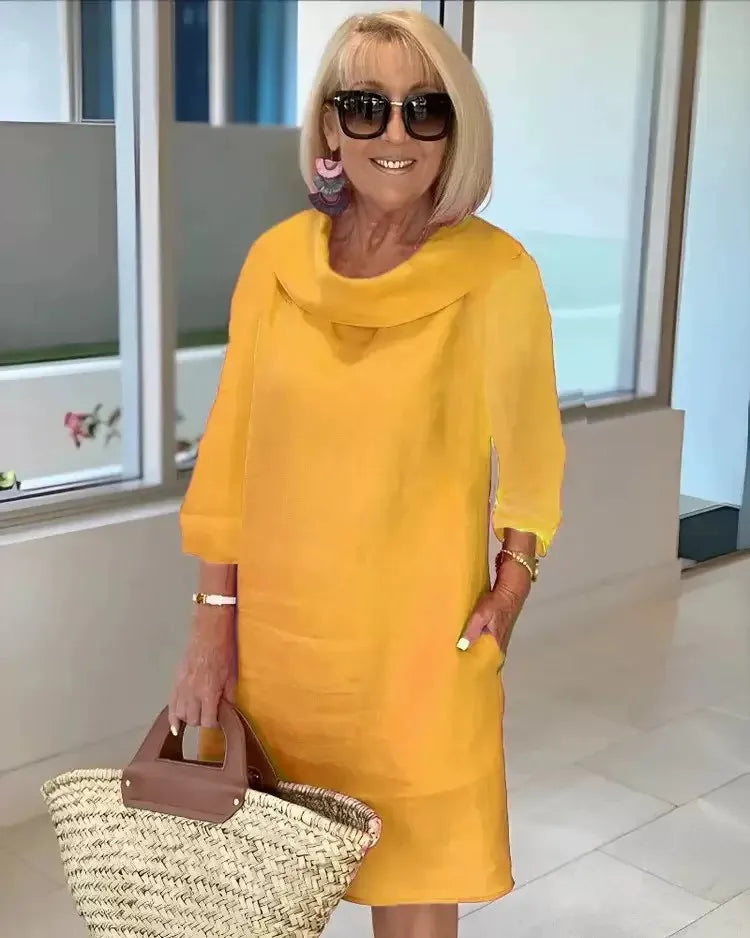 Yellow A-line dress with draped cowl neckline and three-quarter sleeves