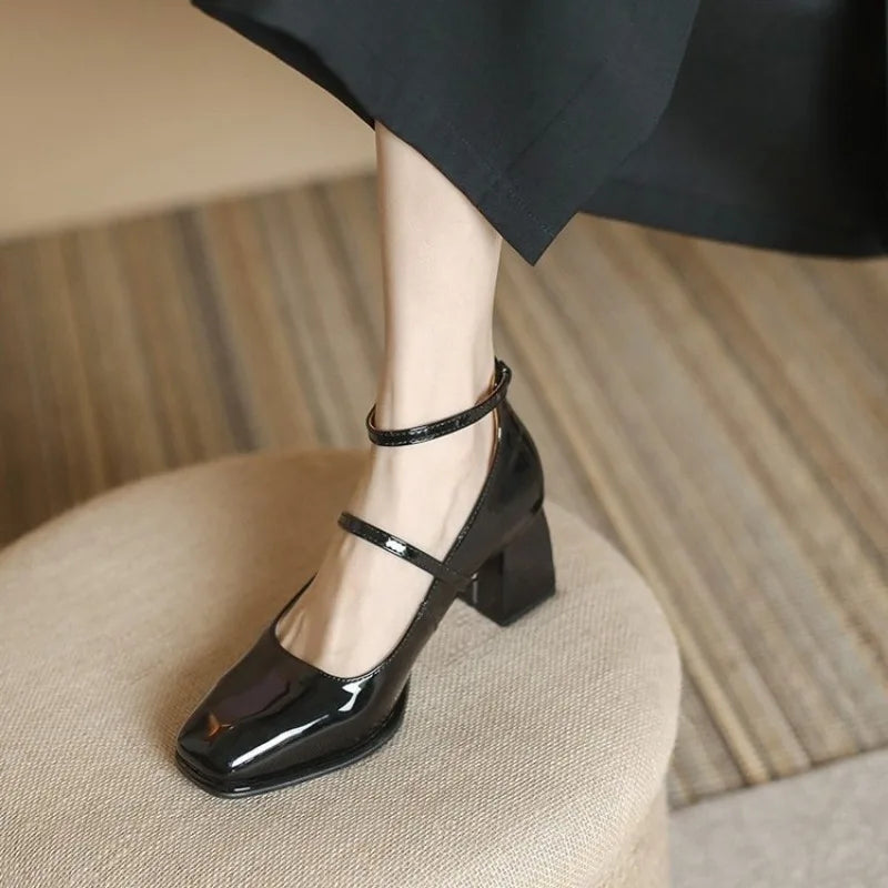 Black ankle-strap pumps with T-strap and block heel, glossy upper