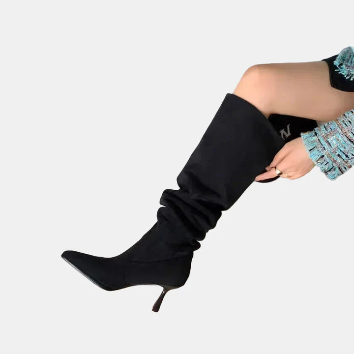 Black pointed-toe heeled cowboy boots with tall slouchy shaft and slim heel
