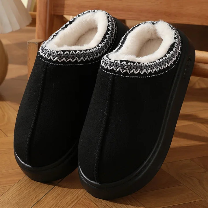 Black platform slippers with white faux-fur lining and braided stitched trim
