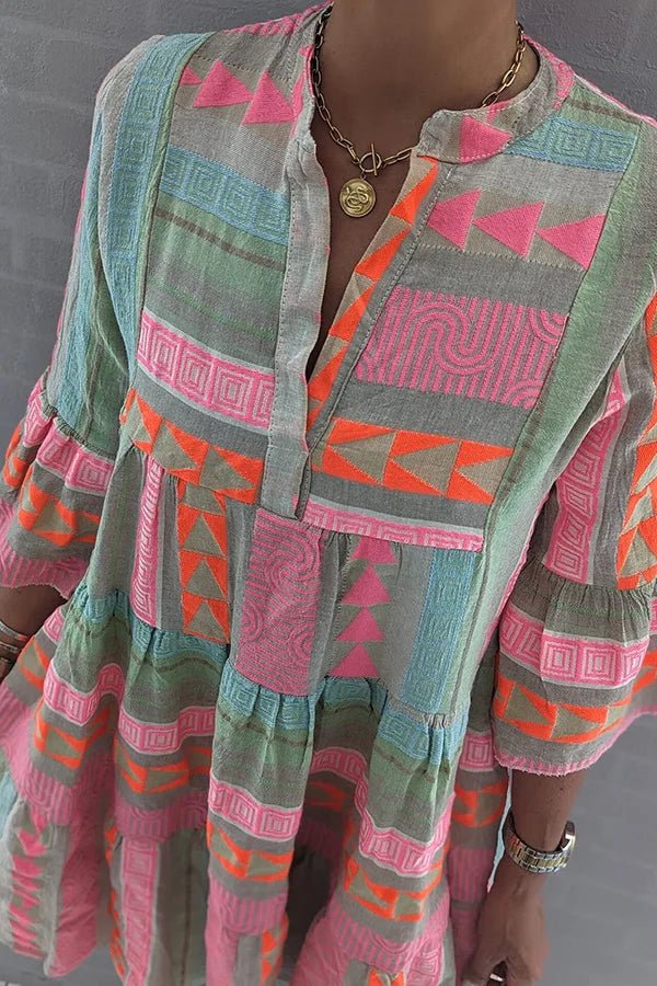 Retro patchwork dress close-up, geometric panels, ruffled sleeve and button front in pink/green
