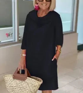 Black A-line dress with draped cowl neckline and three-quarter sleeves