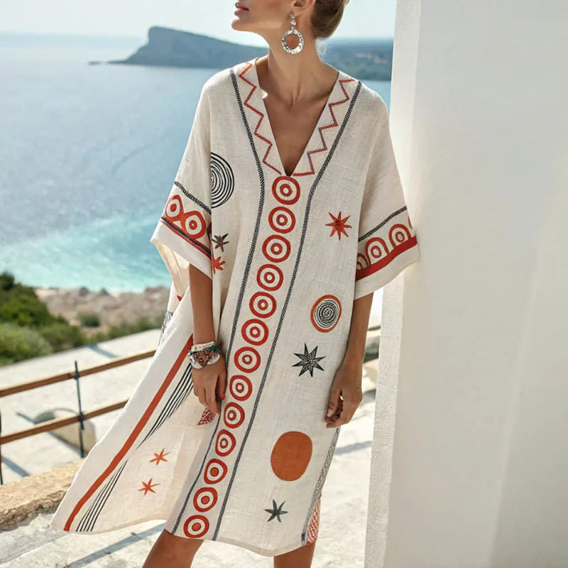 Cream silk beach dress with V neckline, short sleeves, and black-orange geometric print