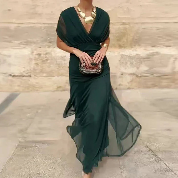 Dark green V-neck dress with short sleeves and draped, flowing hem