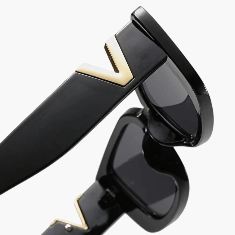 Black sunglasses side view with dark lens and gold V temple accent.