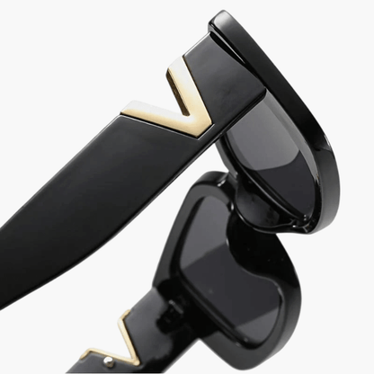 Black sunglasses side view with dark lens and gold V temple accent.