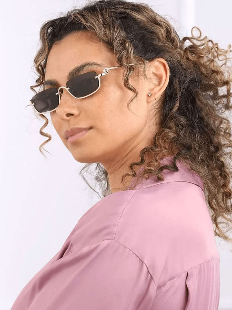 Side view of gold-tone sunglasses with dark lenses and black temples.