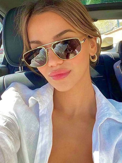 Gold-tone aviator sunglasses with dark lenses on face