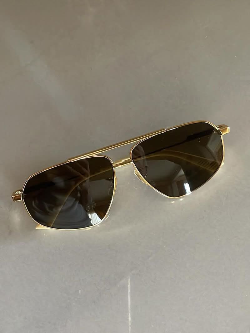 Gold-tone sunglasses with smoky dark lenses, teardrop aviator shape