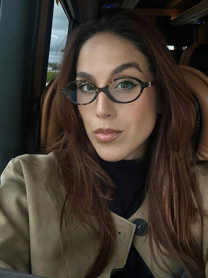 Reading glasses with round dark frames and subtle metal rivets