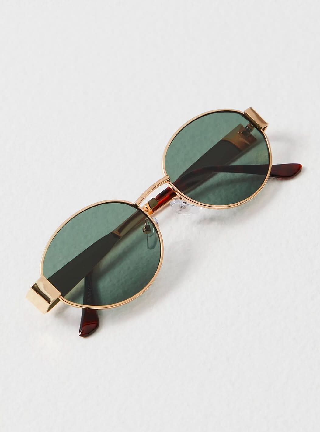 Round sunglasses with gold frame and dark green lenses, side view