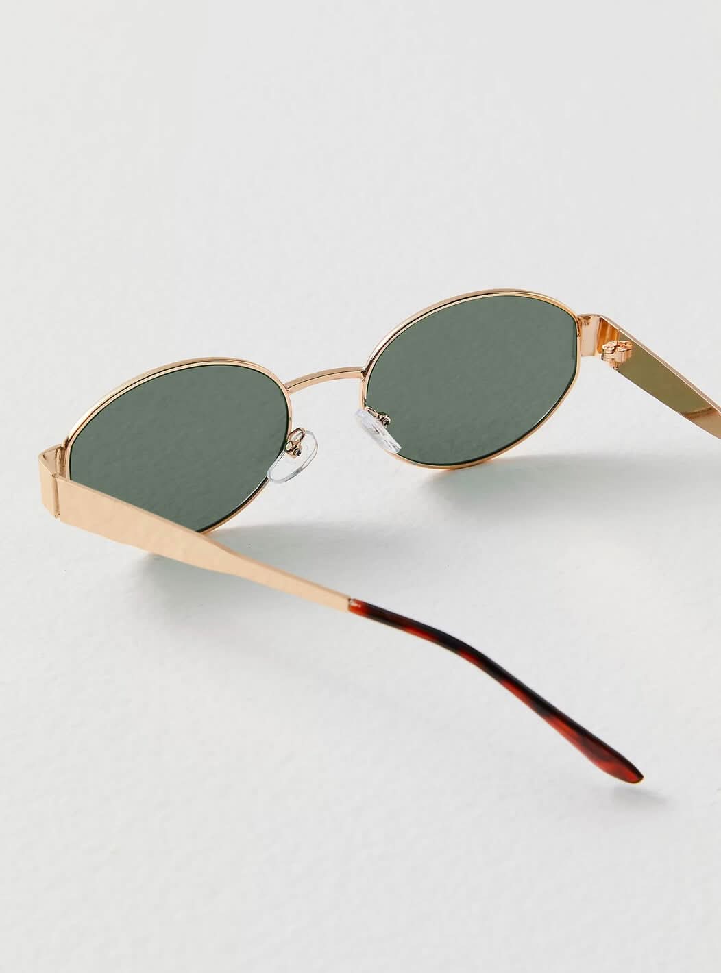 Zariyah stylish sunglasses with gold frame and green tinted oval lenses, side view