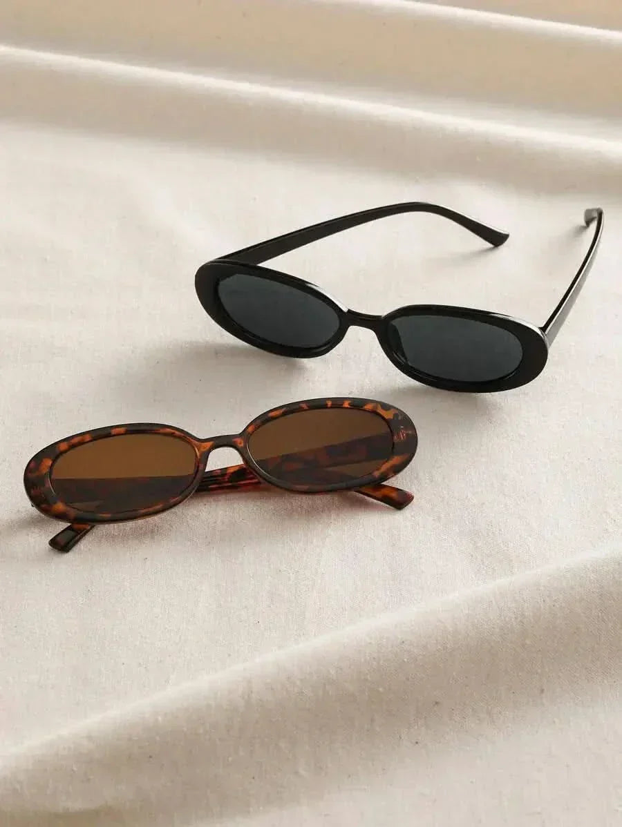 Tortoiseshell and black oval sunglasses with dark lenses, side by side