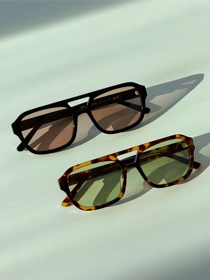 Pair of sunglasses: black frames with brown lenses and tortoiseshell frames with green lenses