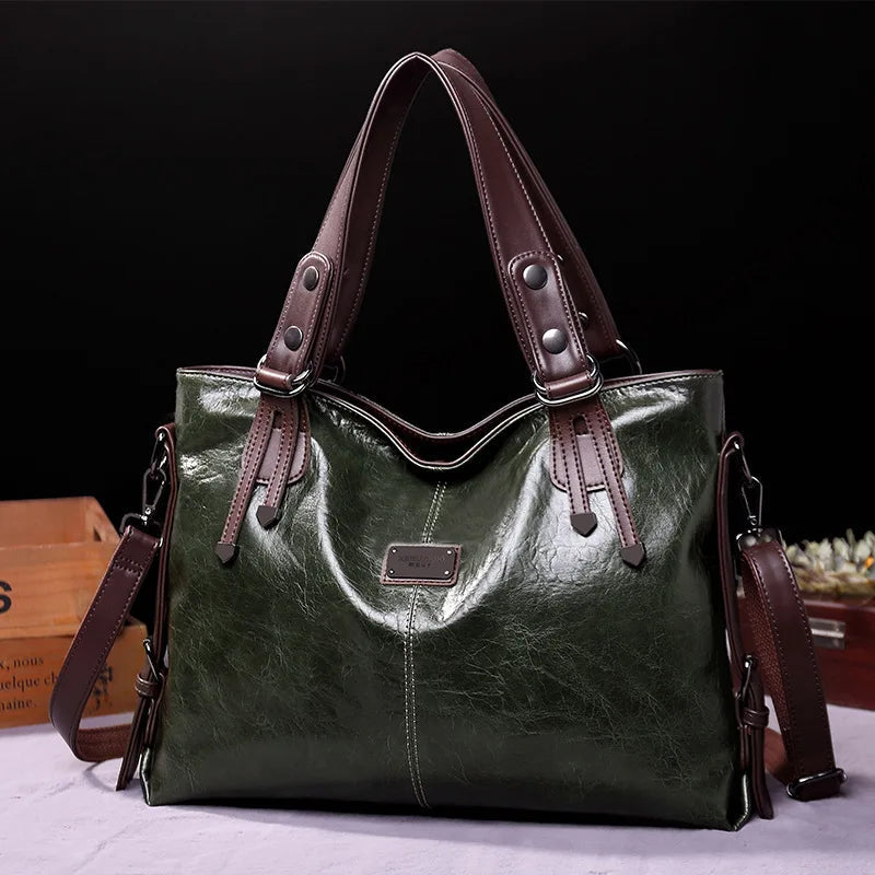 Green soft leather tote bag with double handles, side straps, and front logo patch