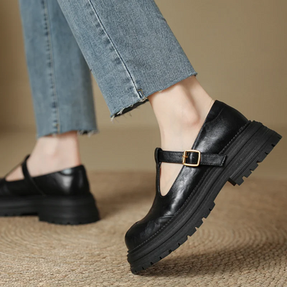Black T-bar shoes with cutout strap, gold buckle, and chunky treaded sole