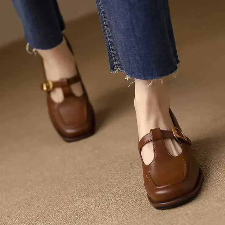 Brown and black T-strap loafers with buckle strap and chunky soles