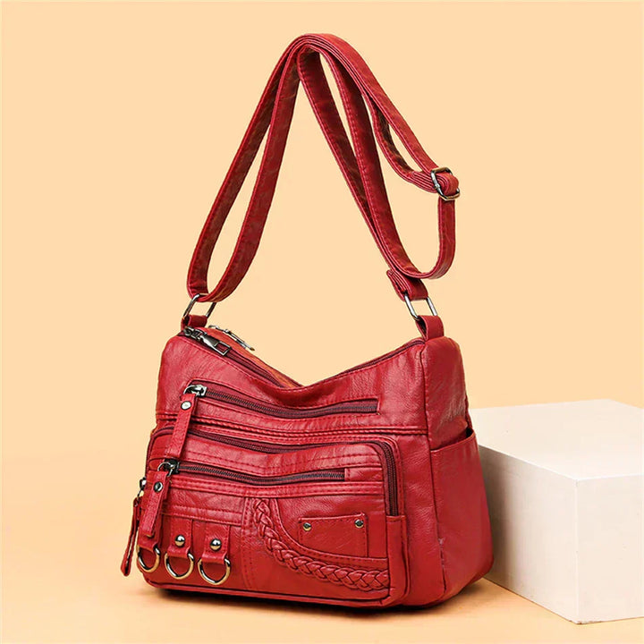 Red multi-layer crossbody bag with top handle, adjustable strap, and front zipper