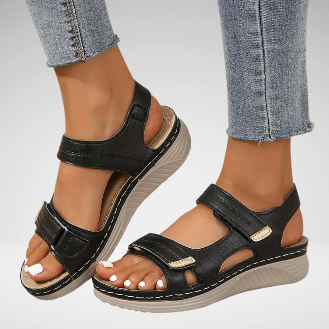 Black orthopedic sandals with hook-and-loop straps and cushioned wedge sole