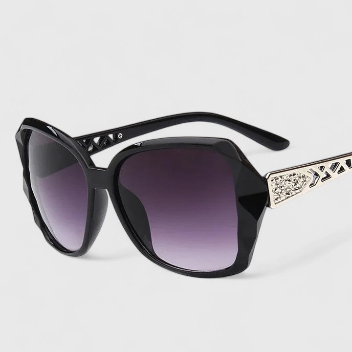 Sophisticated sunglasses, black frame with purple gradient lenses and rhinestone temple bar.