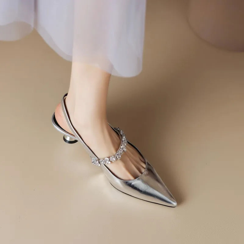 Silver pointed-toe slingback pumps with rhinestone strap and medium heel