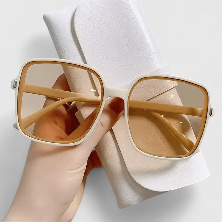 Elegant sunglasses with tan frame and beige tinted lenses, wide square silhouette.