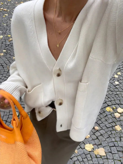 Beige V-neck knit cardigan close-up with button placket and ribbed cuffs