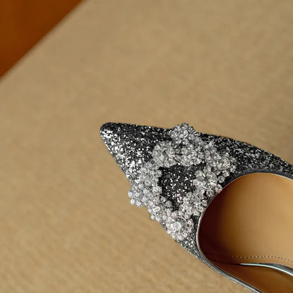 Silver glitter pointed-toe pump with clustered rhinestone bow detail on the upper