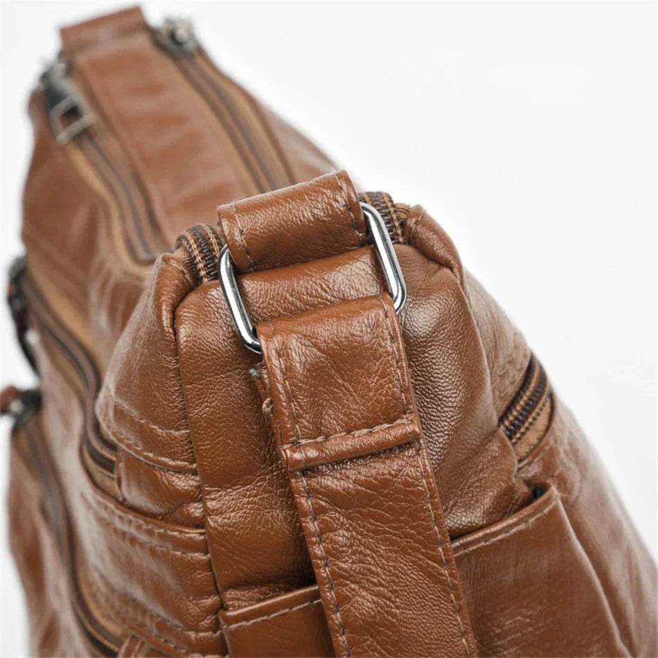 Brown leather multi-layer crossbody bag with adjustable strap and metal buckle hardware
