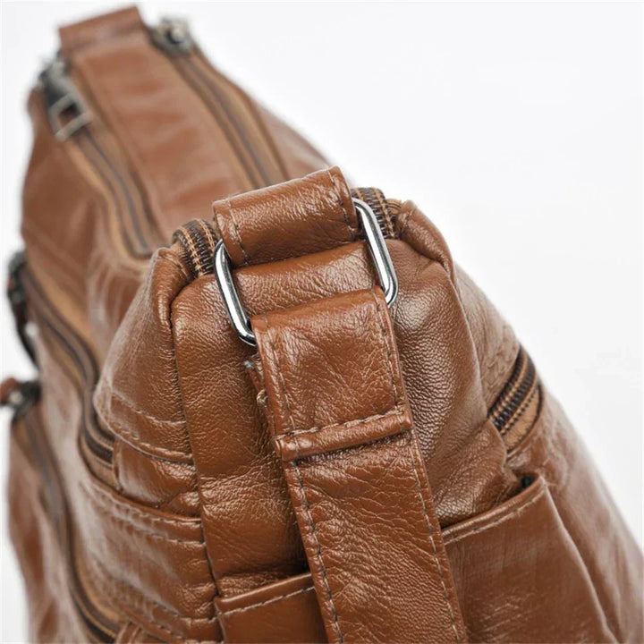 Brown leather multi-layer crossbody bag with adjustable strap and metal buckle hardware