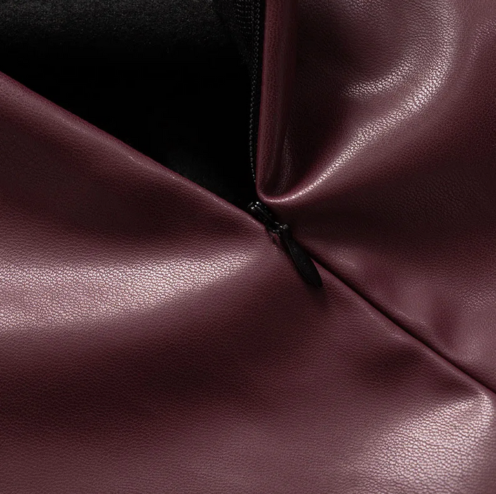 Women’s sleek faux leather top, burgundy close-up with black zipper at the side seam