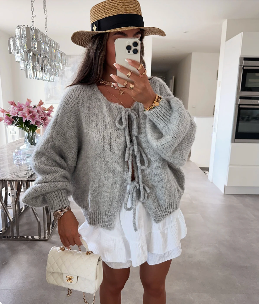 Grey knitted bow cardigan with drawstring bow neckline and relaxed fit.