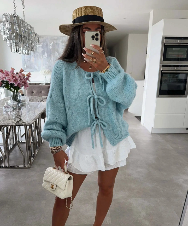 Blue knitted bow cardigan with front bow ties and oversized knit sleeves.