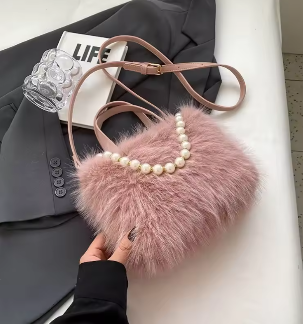 Blush pink faux fur crossbody bag with pearl-bead trim and long shoulder strap