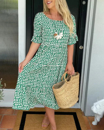 Green and white polka-dot knee-length dress with short sleeves and scoop neckline