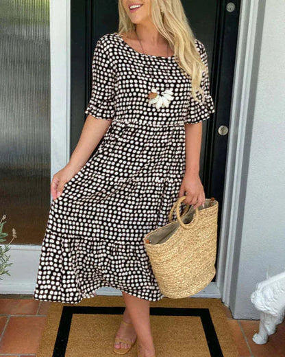Black and white polka-dot knee-length dress with short sleeves and flower applique