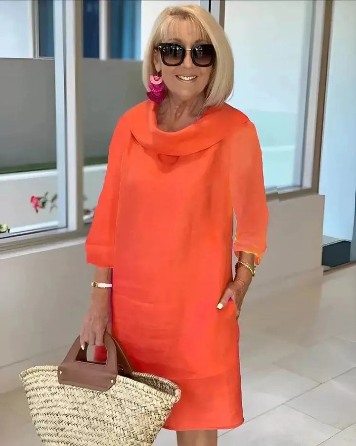 Orange A-line dress with draped cowl neckline and three-quarter sleeves