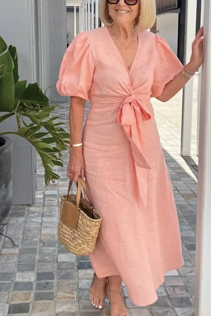 Peach V-neck midi dress with puff sleeves and tied waist, side view