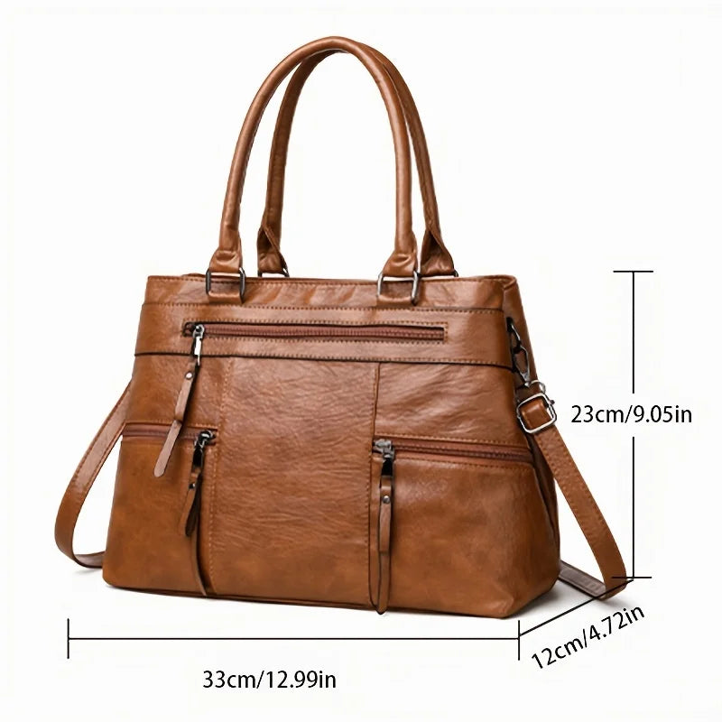 Caramel brown leather tote bag with double top handles, front zip pocket and crossbody strap