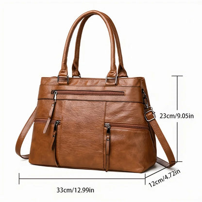 Caramel brown leather tote bag with double top handles, front zip pocket and crossbody strap