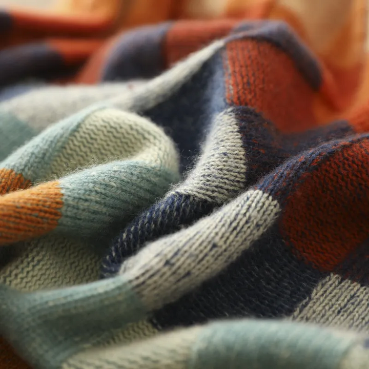 Plaid knit fabric close-up; multicolor square weave with thick ribbing edges.