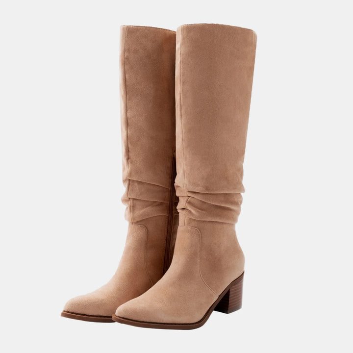 Beige suede knee-high boots with ruched shaft, side zip, and block heel