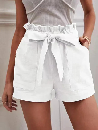 White paper-bag shorts with bow tie, ruffled elastic waist, side pockets.