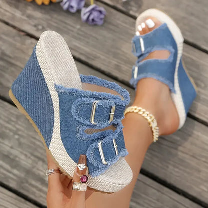 Blue denim wedge sandals with frayed strap edges and two metal buckle accents