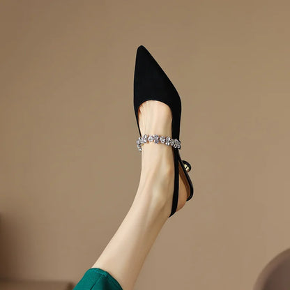 Black pointed-toe slingback pumps with rhinestone ankle strap and slim heel