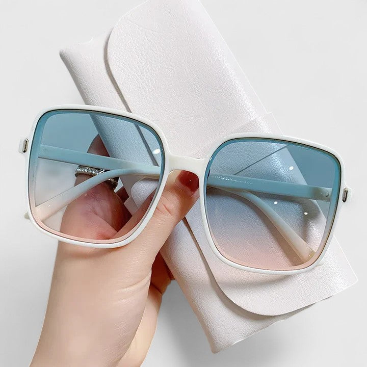 Elegant sunglasses with light blue frame and blue tinted lenses, square wrap design.