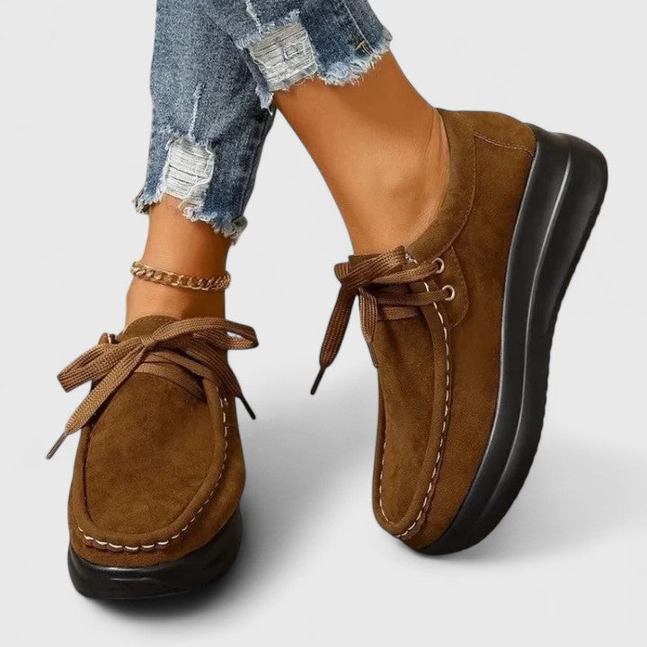 Brown lace-up orthopedic shoe with suede upper and thick black sole.