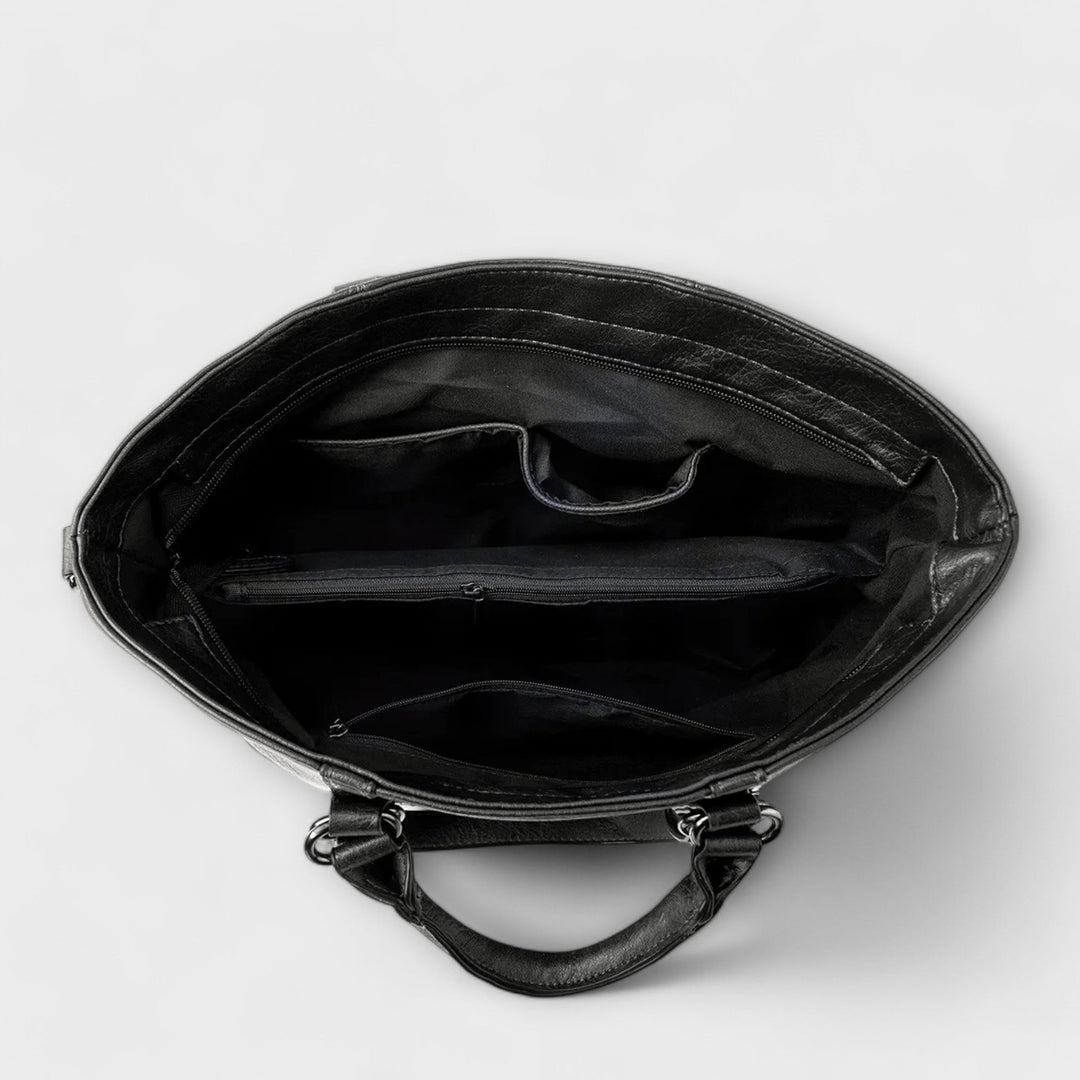 Black leather bag interior view with main compartment and zip pocket lining.