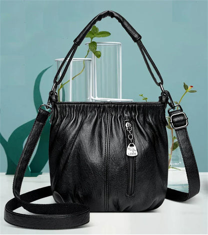Black multi-layer handbag with gathered front and zip pocket detail between handles